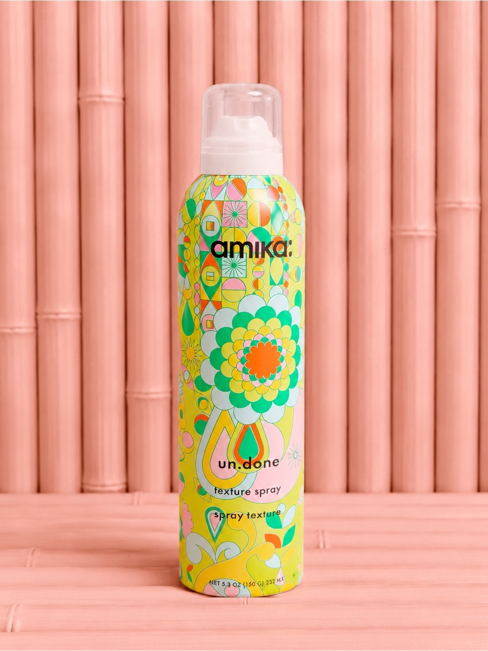 amika texture spray can with green, yellow, orange and pink floral design